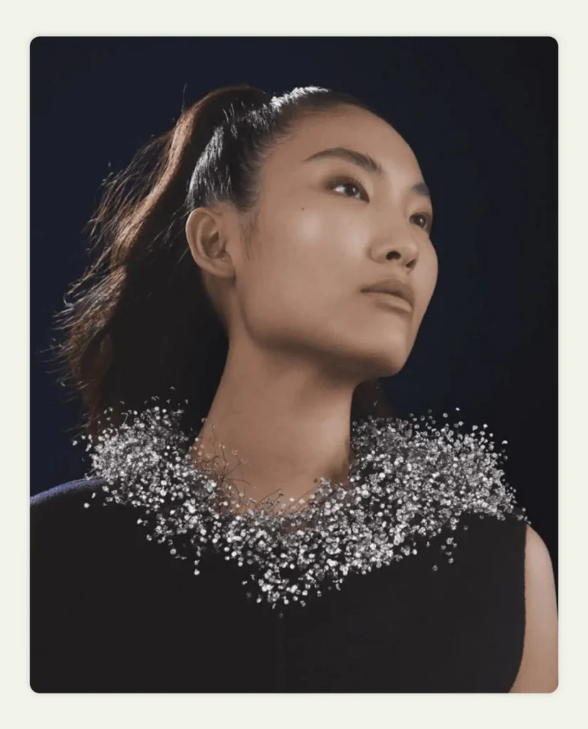 Model wearing intricate silver wire necklace resembling clouds 