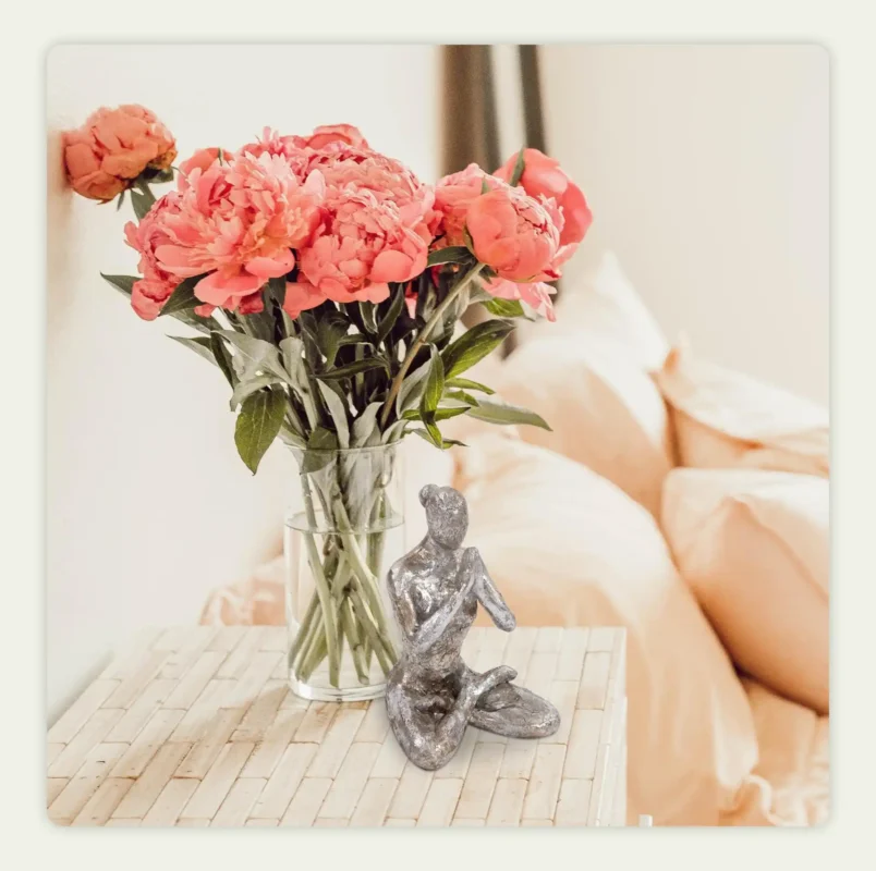 A statue placed next to a flower vase