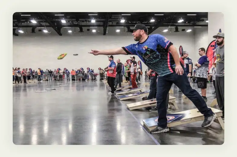 Business professionals playing cornhole bean bag toss game at trade show