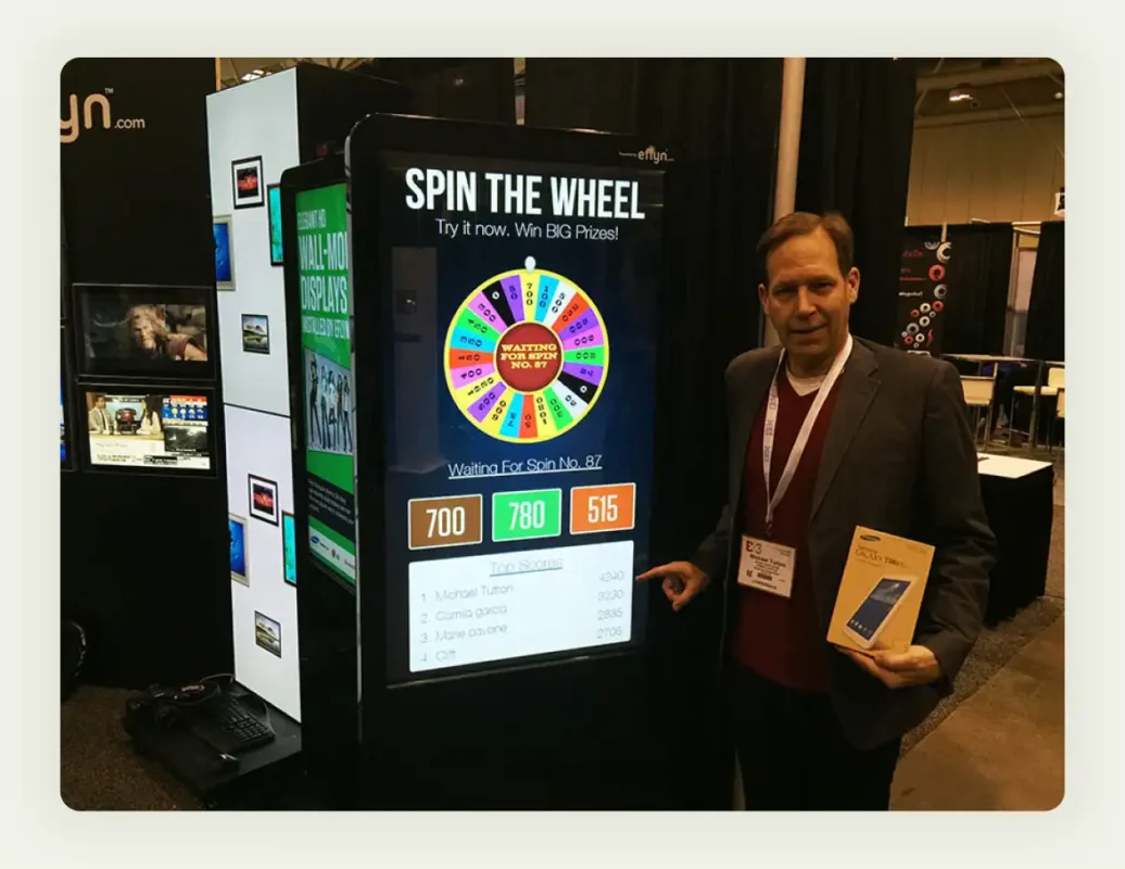 Colorful spin-to-win prize wheel at trade show booth with excited attendees participating Colorful spin-to-win prize wheel at trade show booth with excited attendees participating
